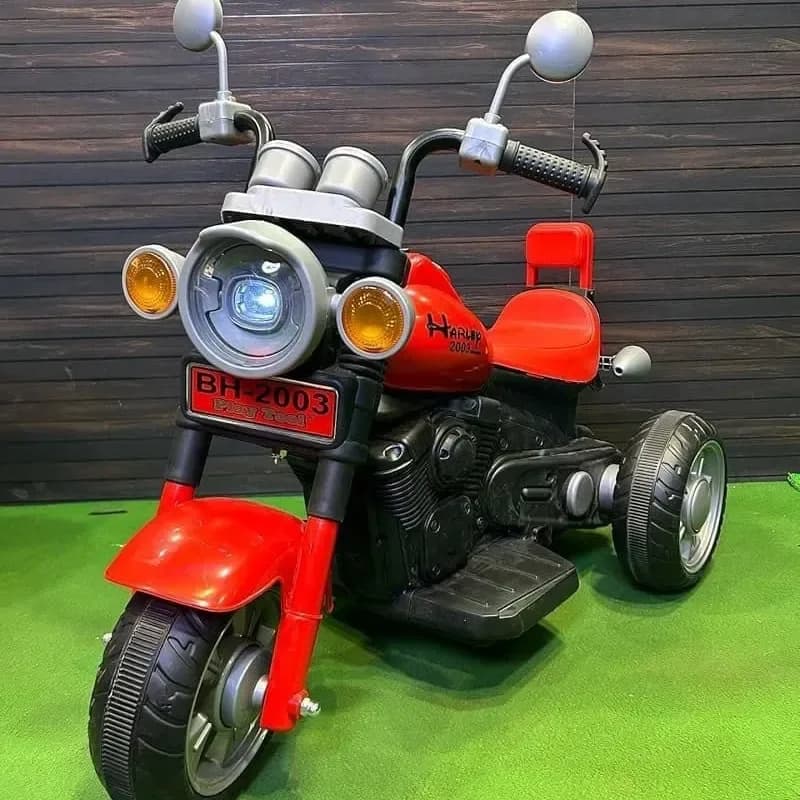 Red Harley-style kids ride-on bike with three wheels and front headlight